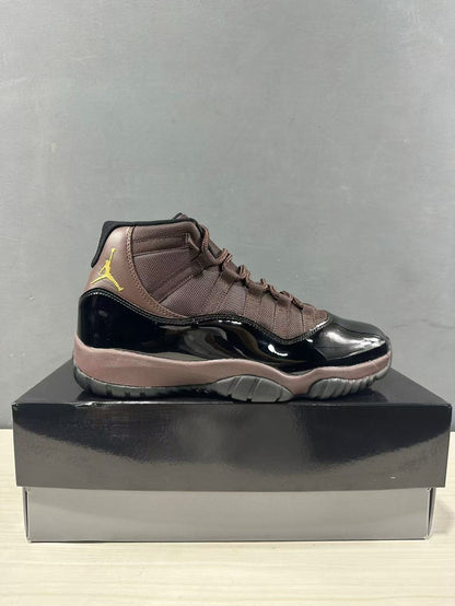 Side profile of the black and bronze high-top sneaker on a black shoebox.