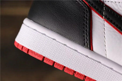 Close-up of the textured white midsole, black upper panel, stitching, and red outsole edge.
