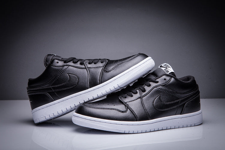 Pair of black low-top Jordan sneakers shown from angled side views with white soles.