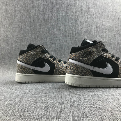 Pair of leopard-print and black mid-top sneakers shown from the side.