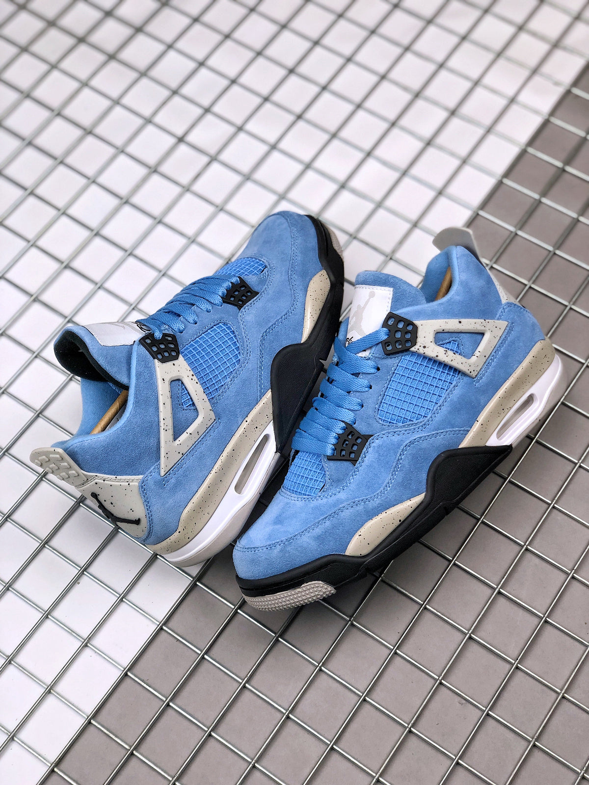 Pair of blue Air Jordan 4 sneakers displayed from an angled top view.