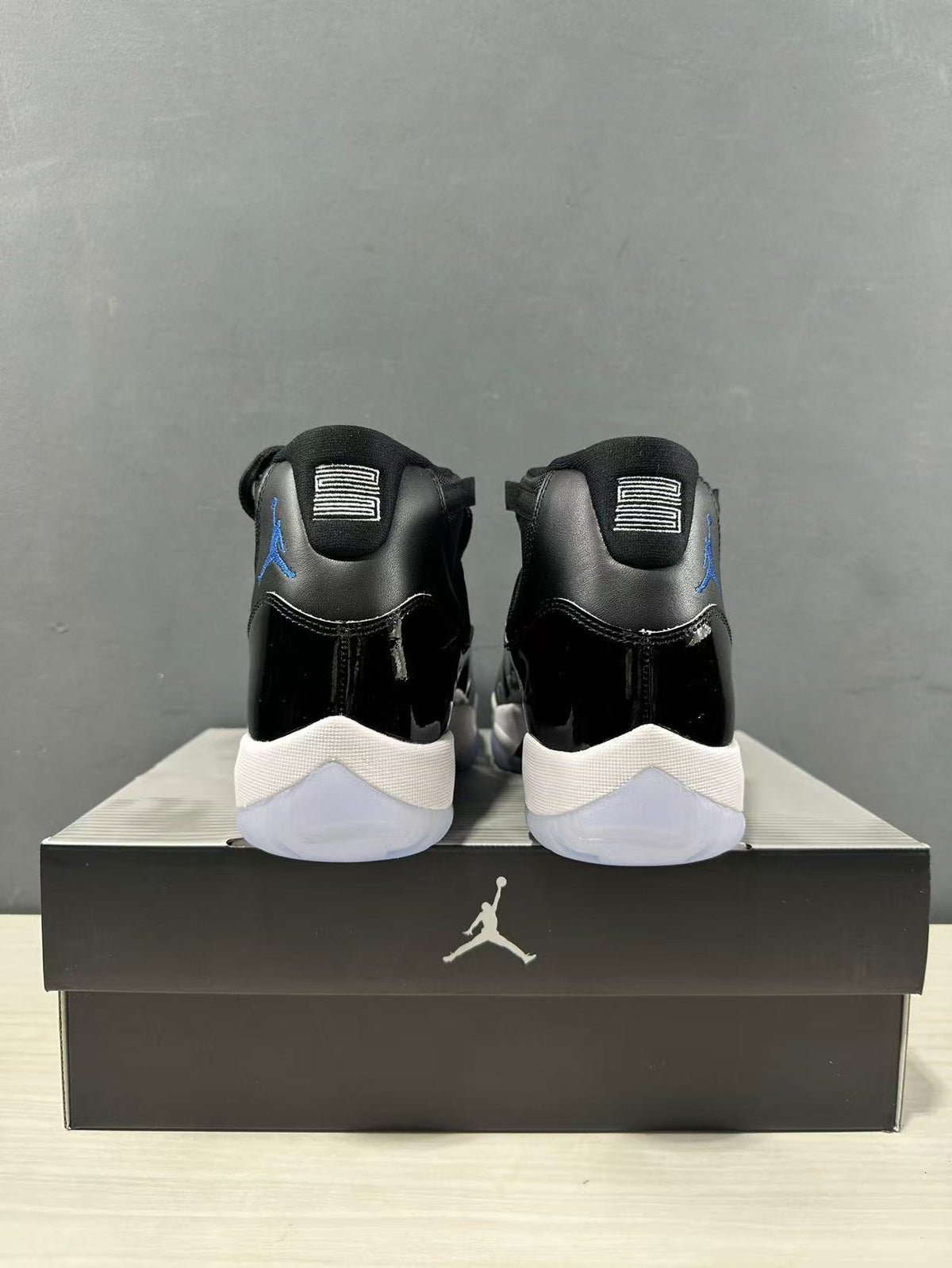 Rear view of the pair showing the black heel panels, blue side branding, and white midsoles.