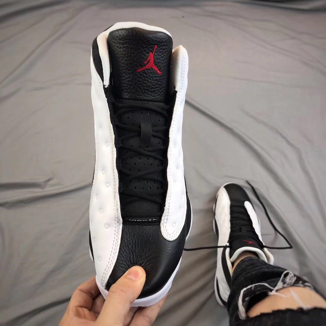 Front view showing the black tongue, red Jordan emblem, black laces, and white side panels.