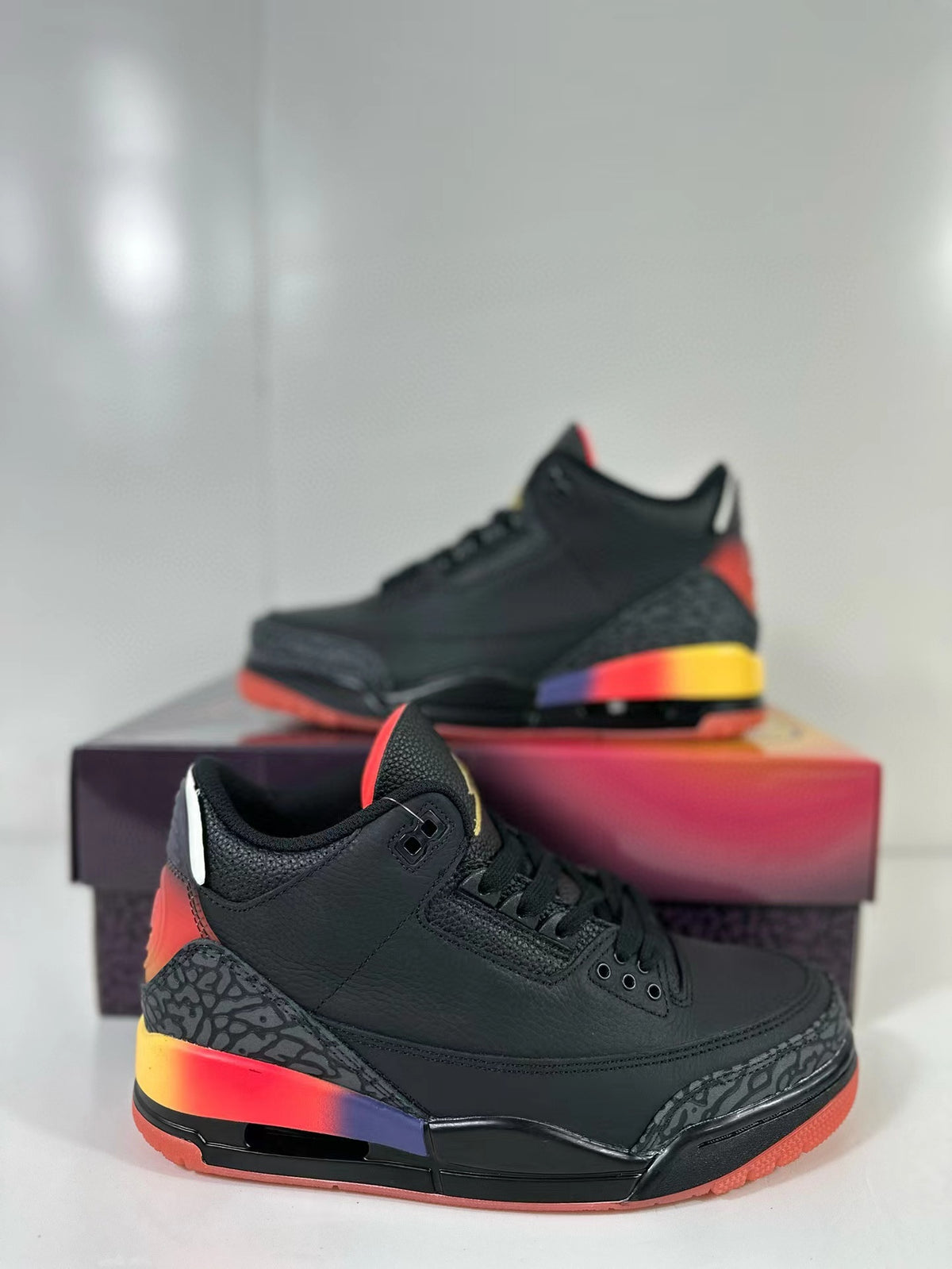 Close side view of the black Air Jordan 3 sneaker showing elephant-print overlays and a multicolor gradient midsole accent.