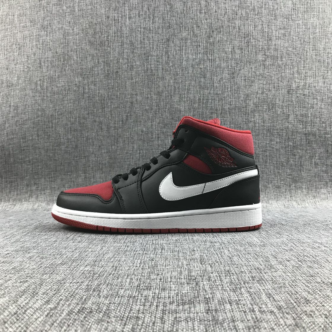 Full lateral profile of a black and red mid-top sneaker with a white Swoosh and white midsole.