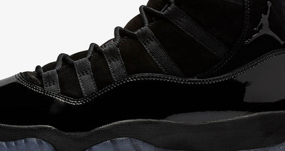 Close-up studio view of the black laces, glossy side panel, and midsole.