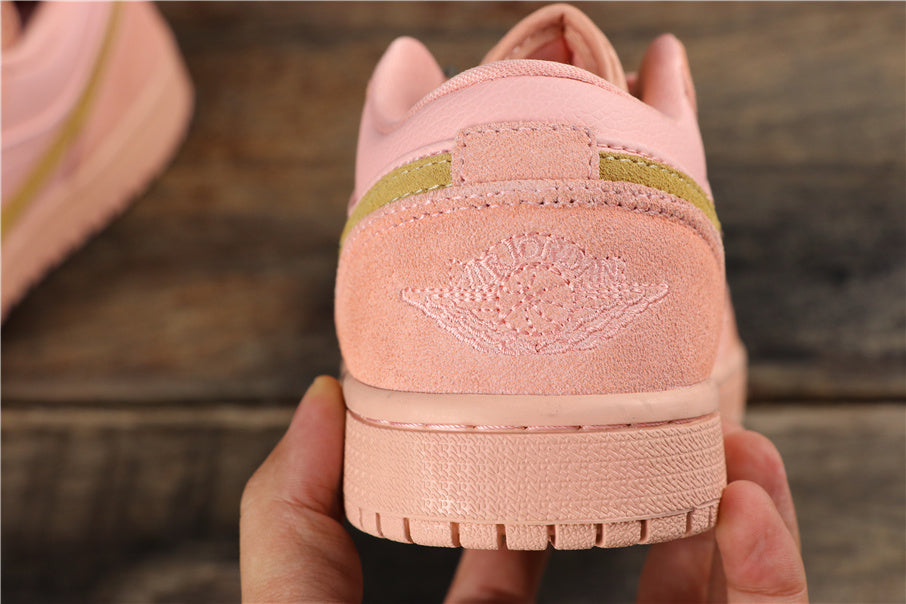 Close-up of the coral pink sneaker heel showing stitched Jordan Wings branding, a gold-toned heel accent, and textured outsole.