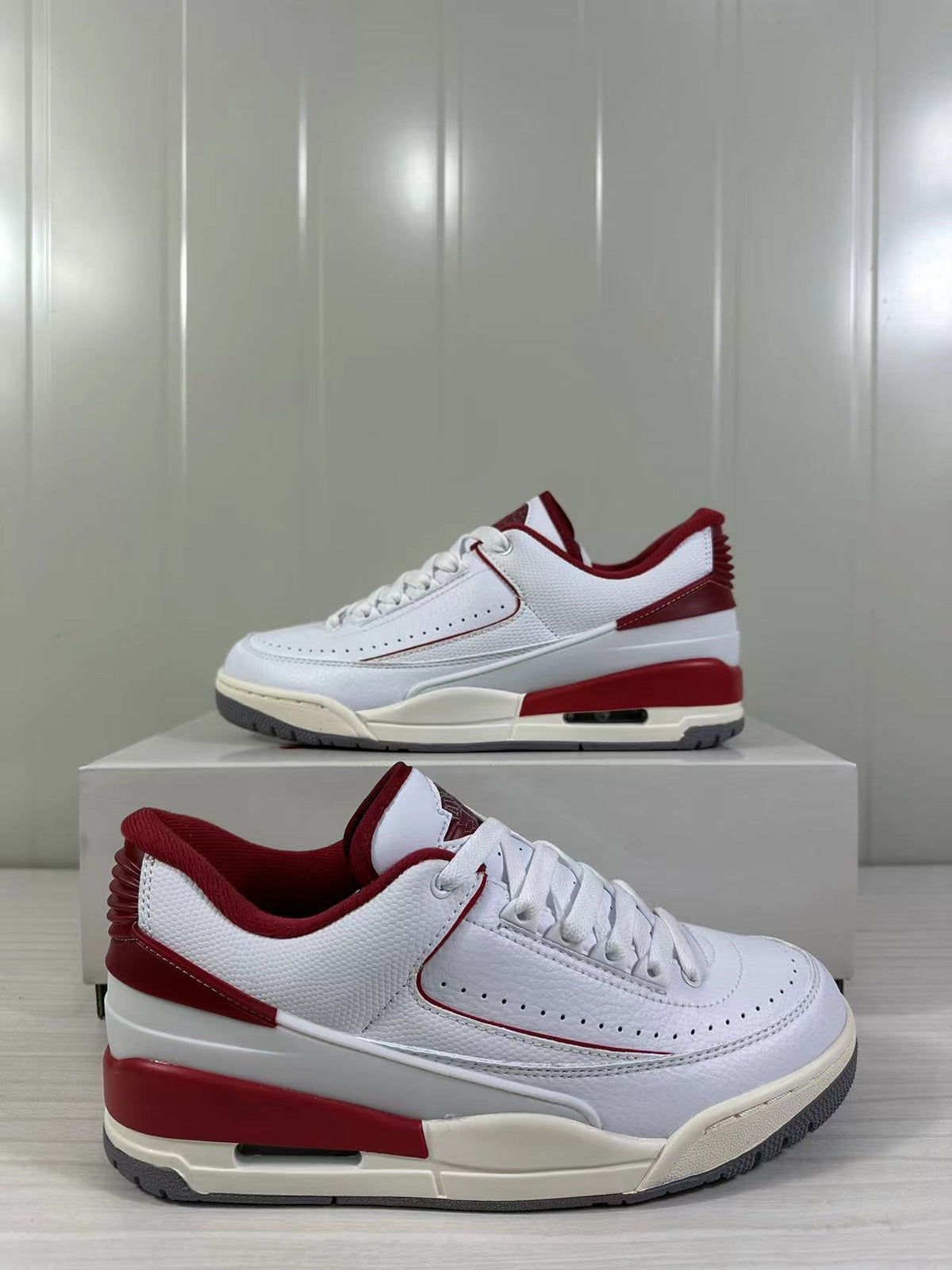 Side profile of the white and red low-top sneaker with perforated detailing and a visible outsole window.