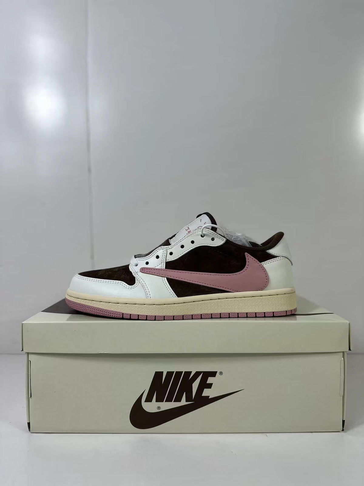 Side profile highlighting the low-top shape, brown upper panels, white overlays, and pink Swoosh.