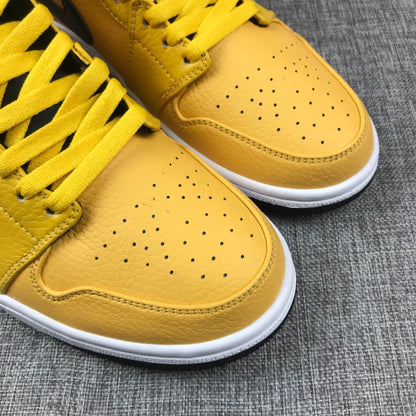 Close-up of the perforated yellow toe panels and yellow laces.