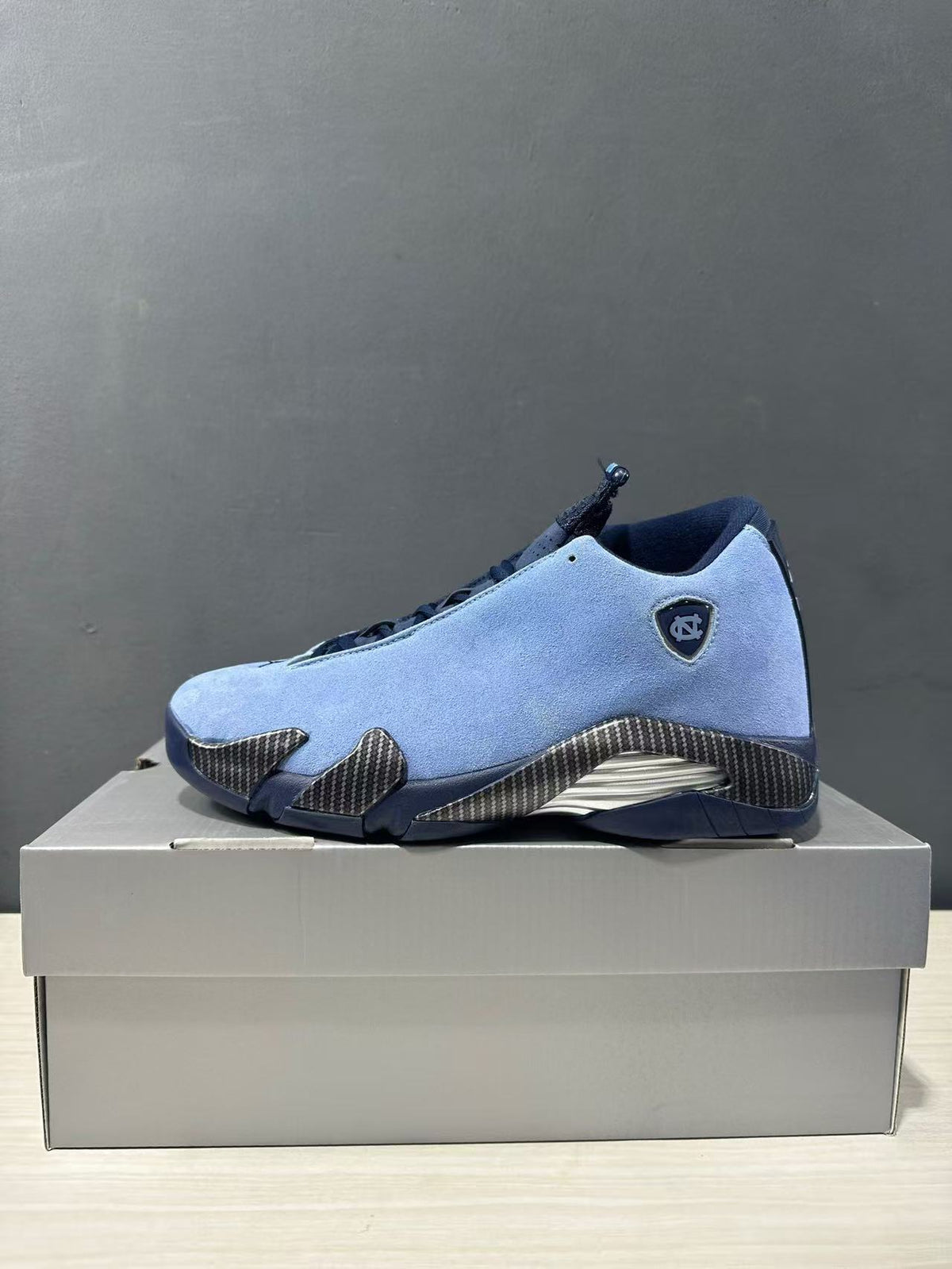 Single blue Jordan Air Jordan 14 sneaker shown in side profile with navy accents and textured side panels.