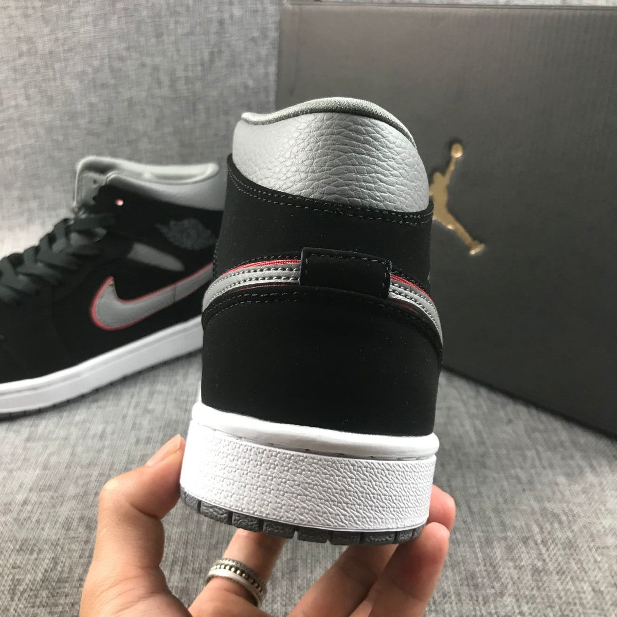 Close-up of the heel showing the grey padded collar, black heel and layered outsole.