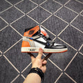 Side profile highlighting the high-top shape, orange heel panel, black overlays, and printed midsole quotation.