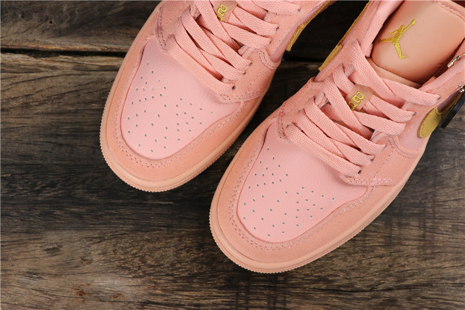 Top view of the coral pink sneaker pair showing perforated toe panels, matching laces, and visible Jumpman tongue details.