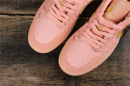 Top view of the coral pink sneaker pair showing perforated toe panels, matching laces, and visible Jumpman tongue details.