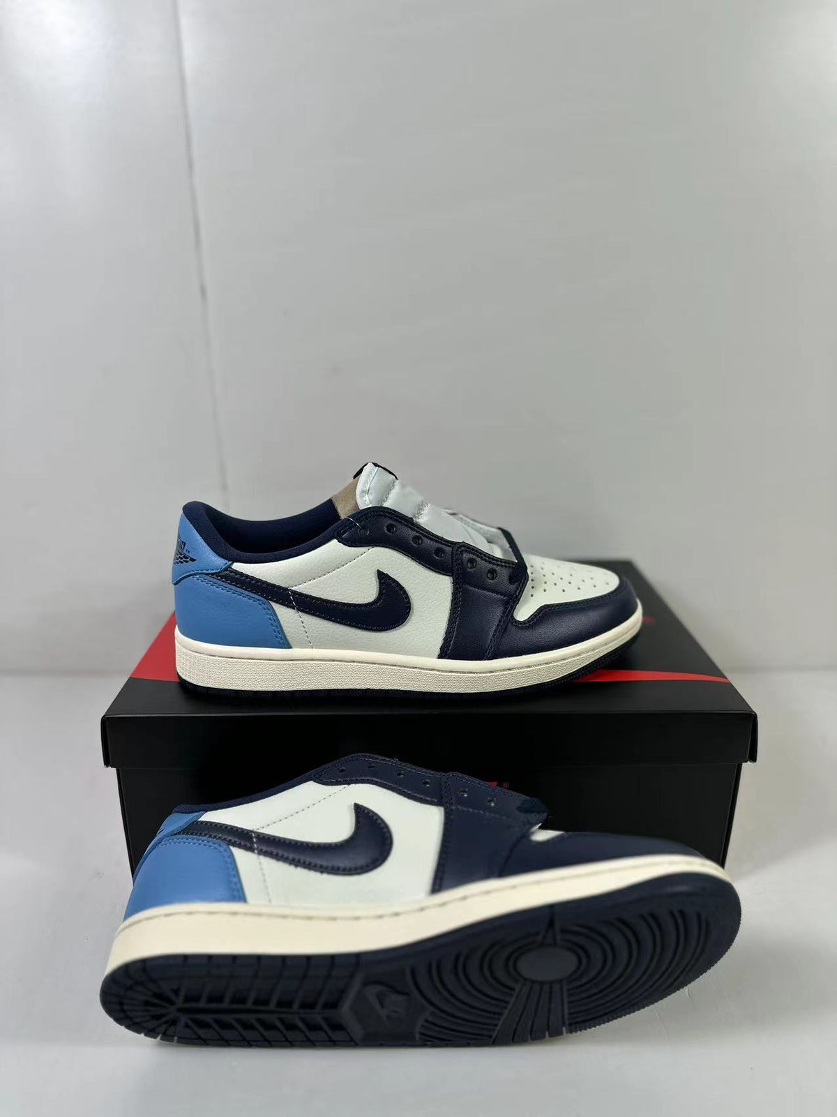 Pair of low-top sneakers showing the white, obsidian, and blue color blocking and textured outsole.
