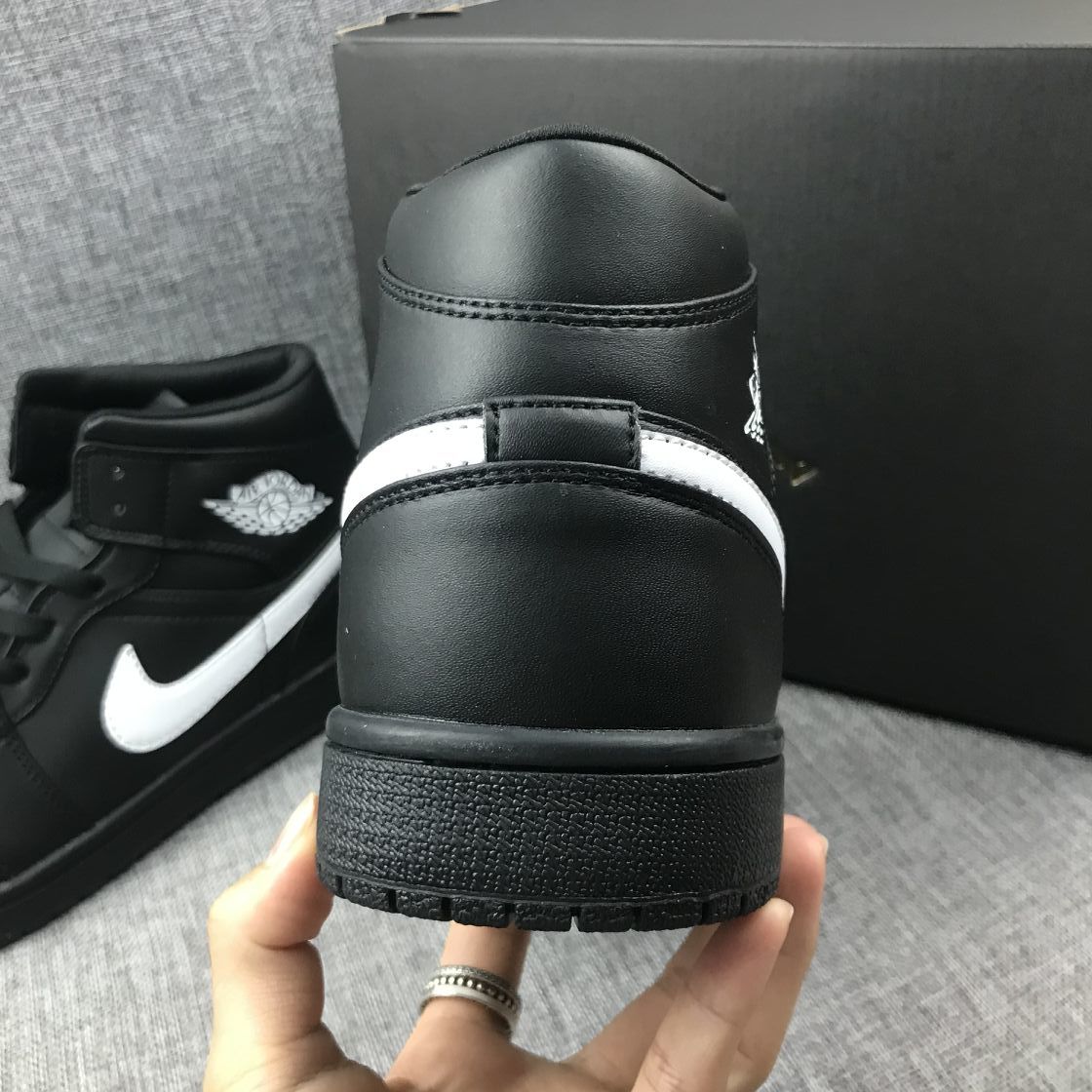 Rear view of the black sneaker showing the padded collar, heel panel and rubber outsole.