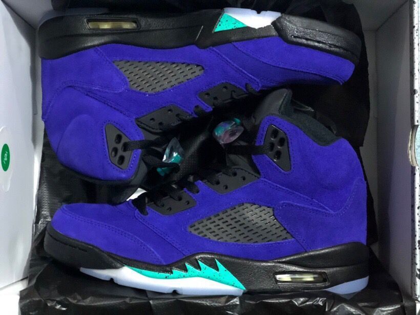 Pair of purple and black high-top sneakers shown in an open shoe box, with turquoise midsole accents and translucent outsoles.