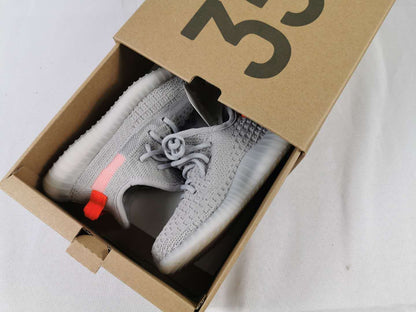 Gray and pink kids sneakers displayed inside a brown shoe box.