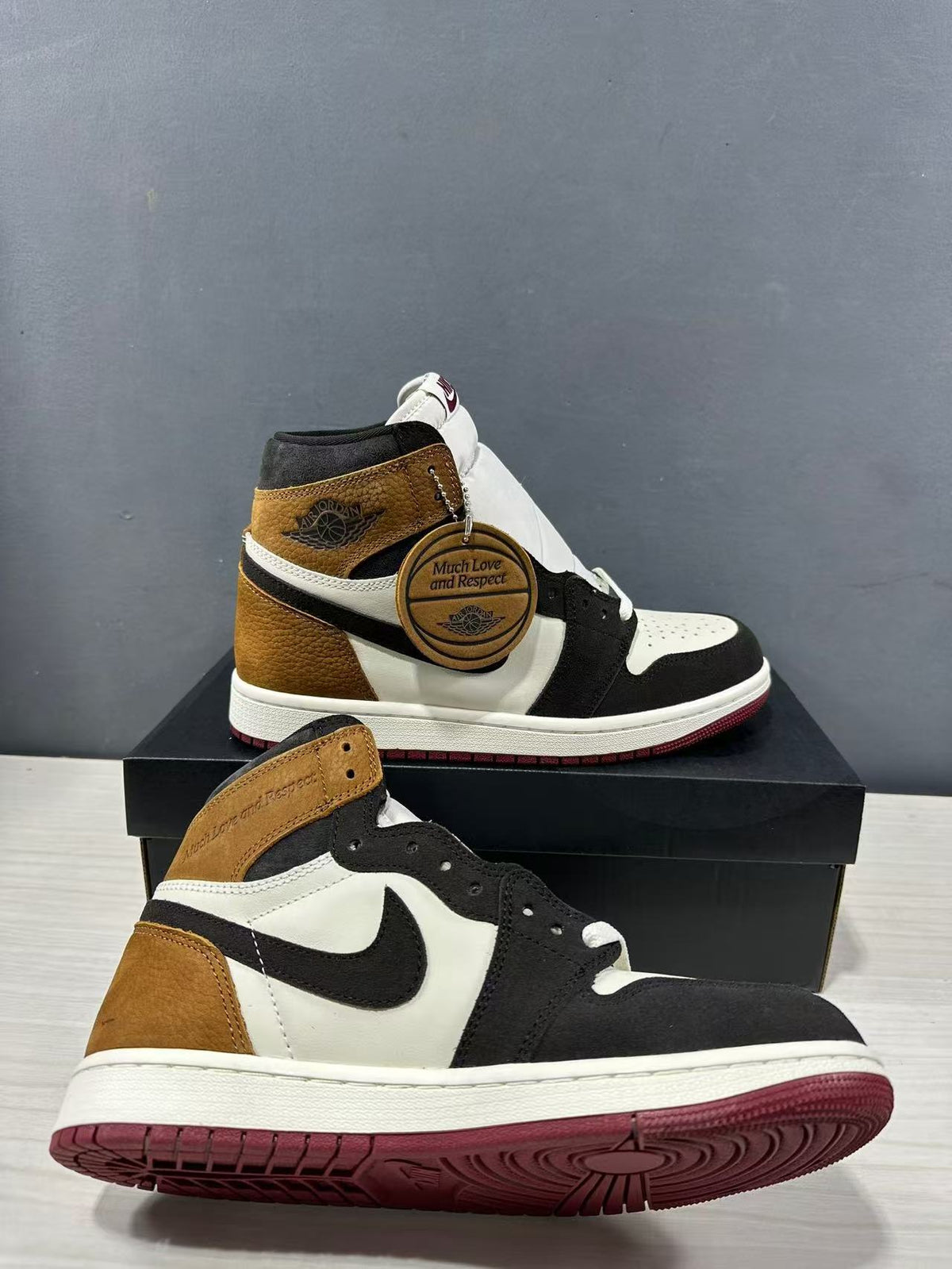Angled view of the high-top sneaker showing the contrasting panels, side logo and burgundy outsole.
