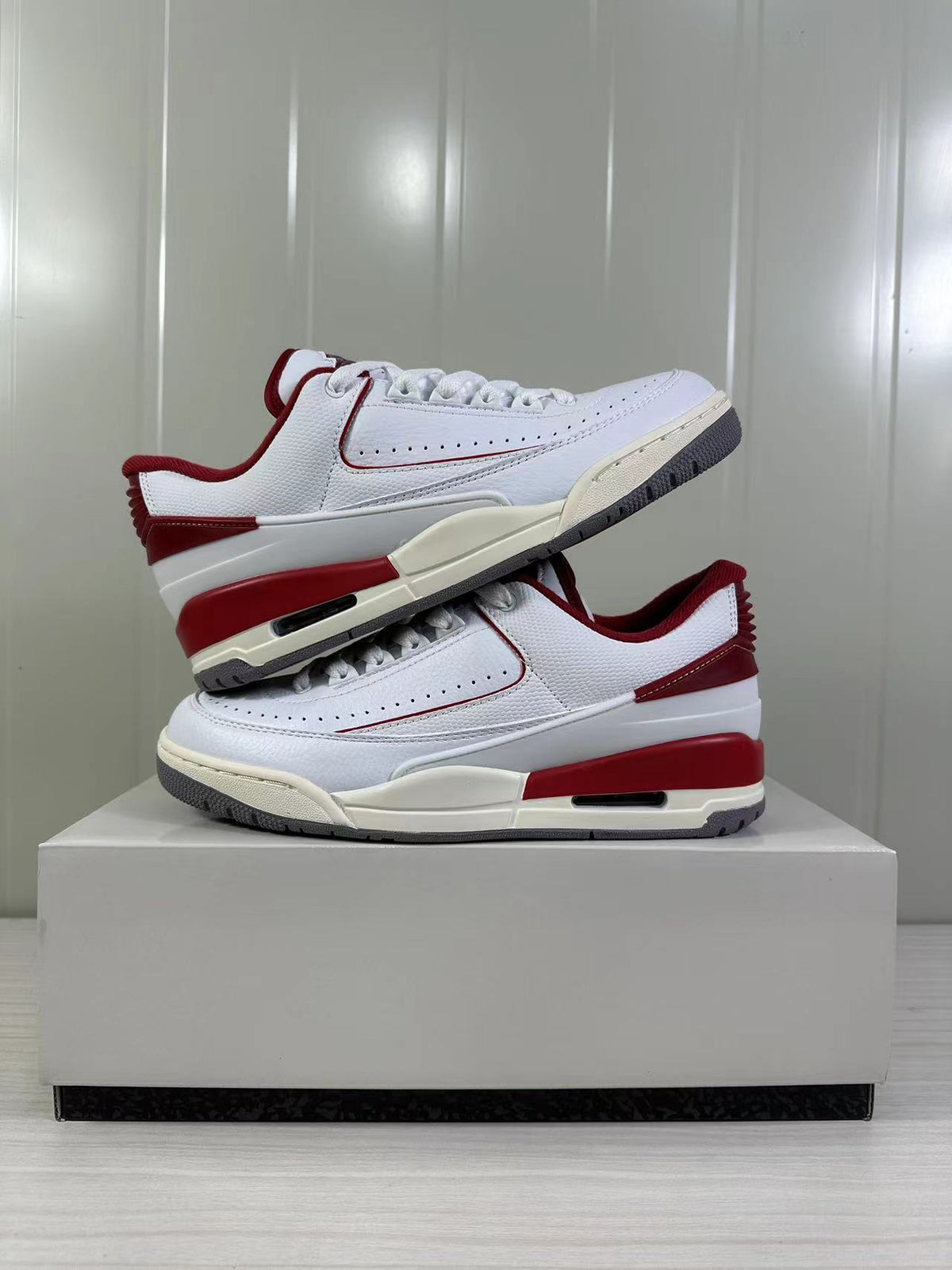 Angled display of the pair showing the lateral panels, red accents, and gray tread.