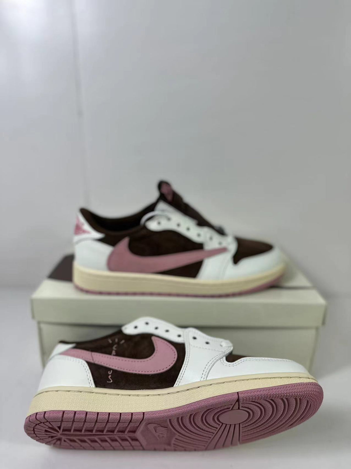 Angled side view showing the pink reversed Swoosh, brown panels, and white overlays.
