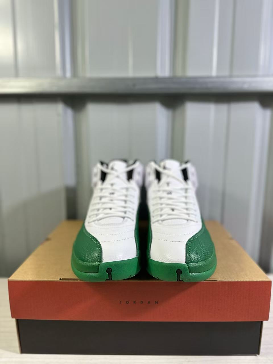 Front view of the pair showing white laces, white uppers and green toe sections.