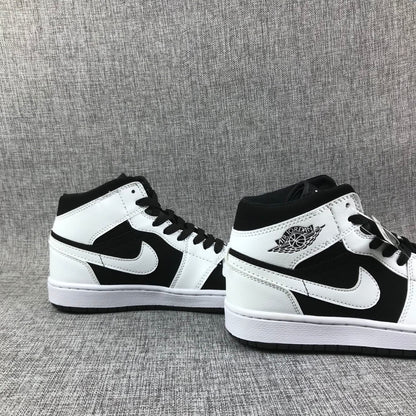 Pair of black-and-white Jordan Air Jordan 1 Mid sneakers shown from angled side views.