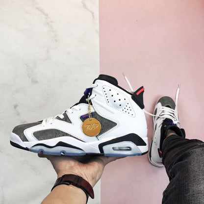 Side profile of the Air Jordan 6 Flint sneaker showing its high-top shape, grey overlays, white upper, black accents, and translucent outsole.