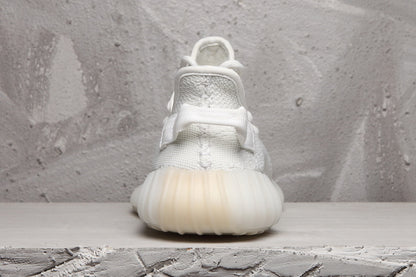 Rear view of a white Yeezy 350 V2 sneaker showing the heel pull tab and ribbed sole.