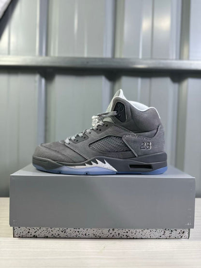 Side profile of a grey high-top sneaker with a ventilated side panel, number 23 detail, black midsole, and translucent outsole.