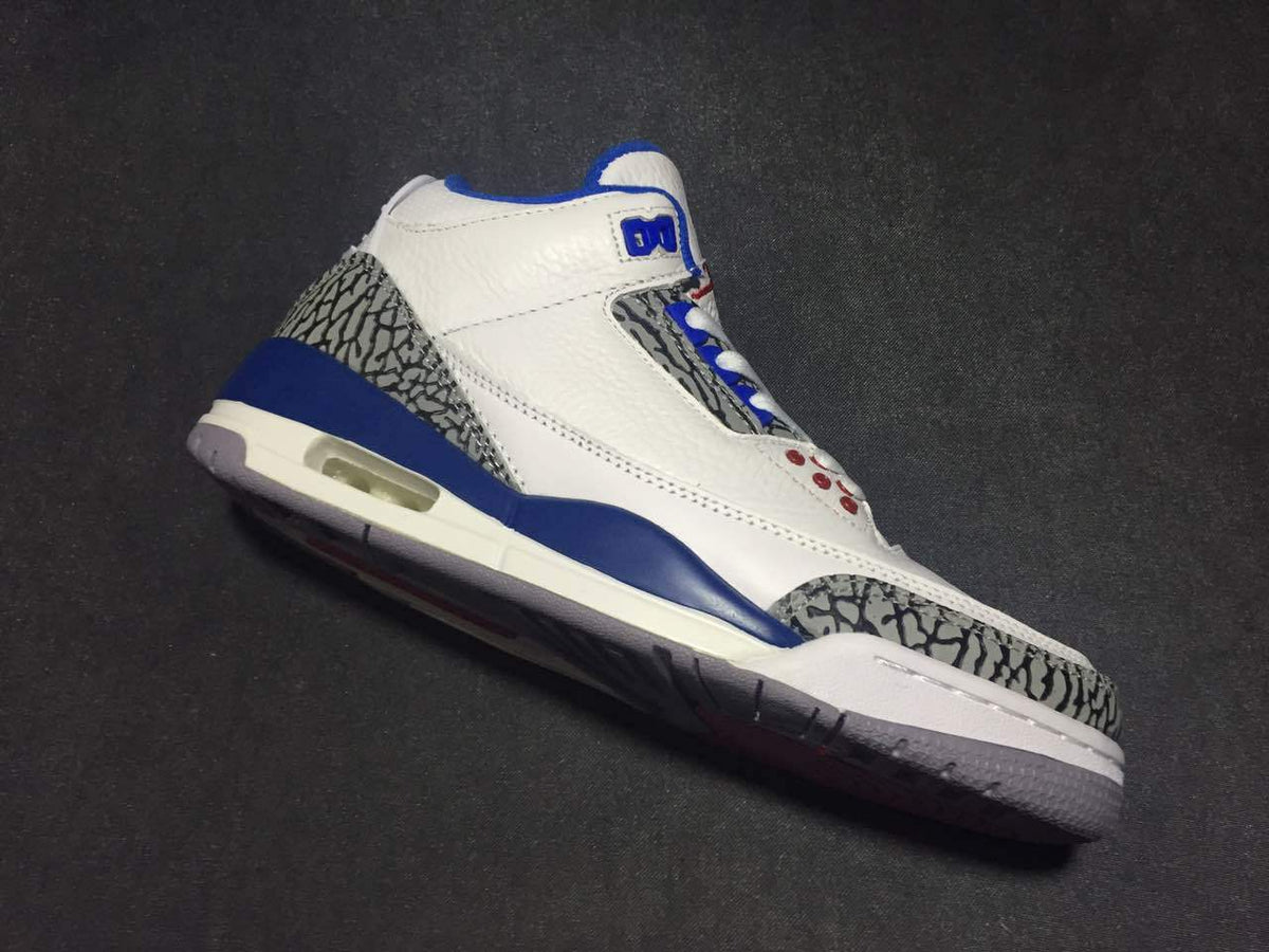Angled side view highlighting the white upper, blue midsole accents, elephant-print overlays, and visible air window.