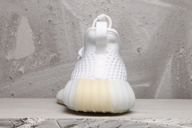 Rear view of a white sneaker showing the heel pull tab, textured upper, and ribbed translucent sole.