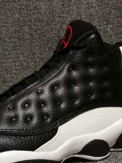 Close-up of the black textured upper, stitching, and red tongue accent