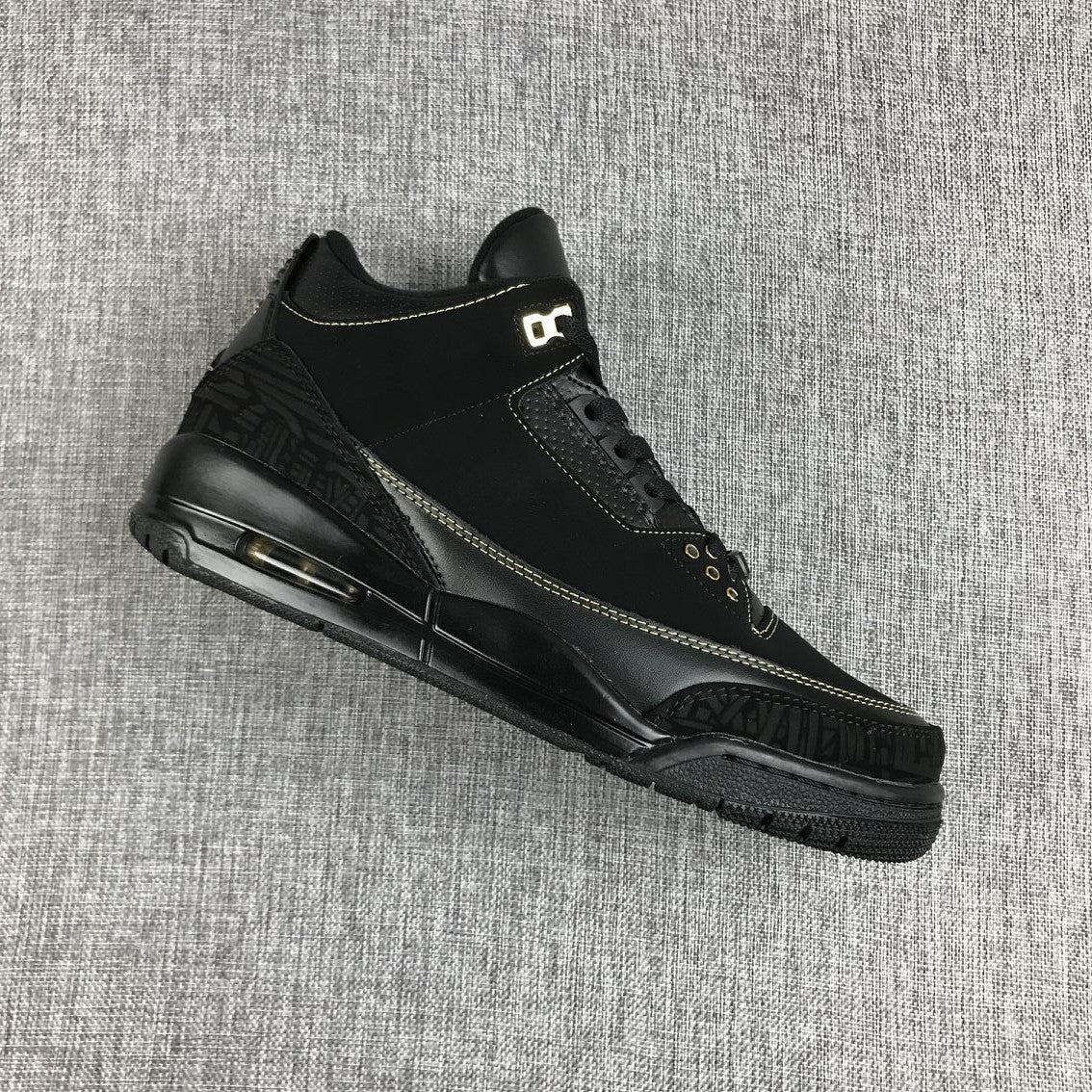Angled side view of the black and gold Jordan Air Jordan 3 BHM sneaker