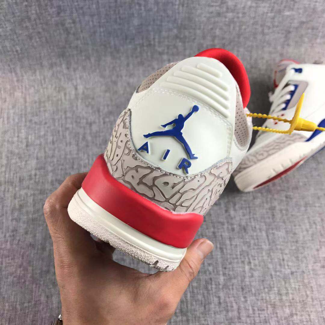 Rear view showing the blue Jordan heel logo, patterned grey heel panel, red heel accent, and white outsole.