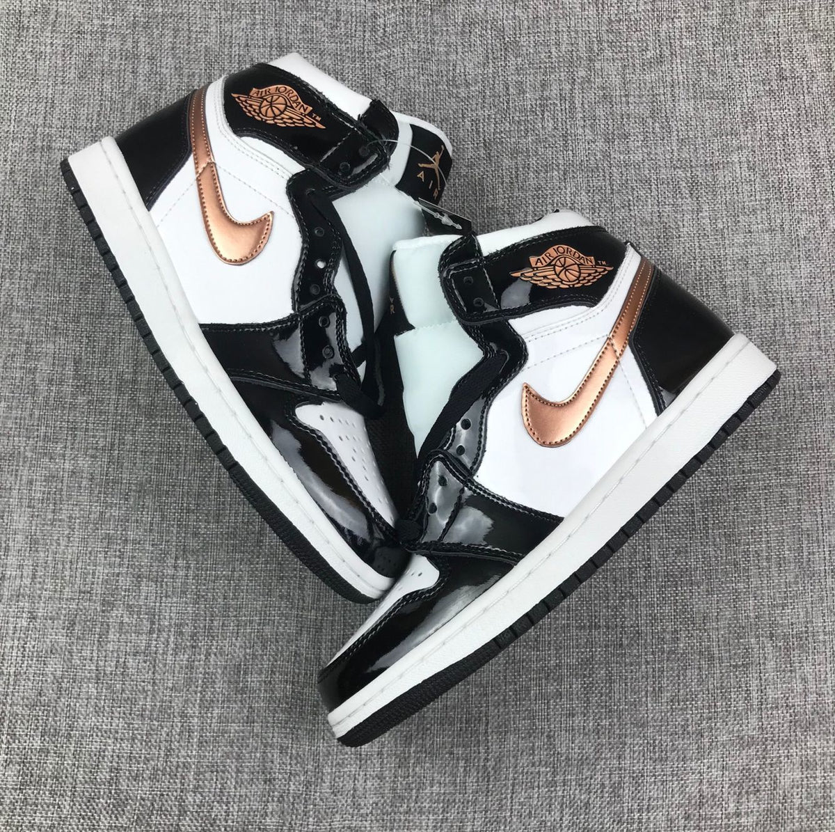 Pair of black, white and metallic-gold high-top sneakers arranged diagonally.