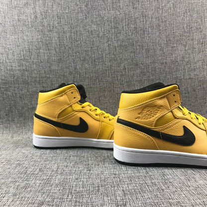 Pair of yellow and black mid-top sneakers displayed from angled side views.
