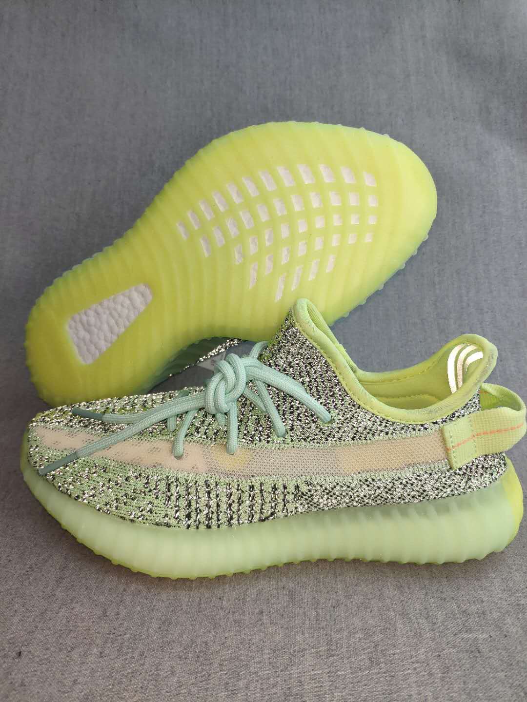 Side view of a green and black patterned sneaker with a contrasting stripe and translucent green-toned sole.