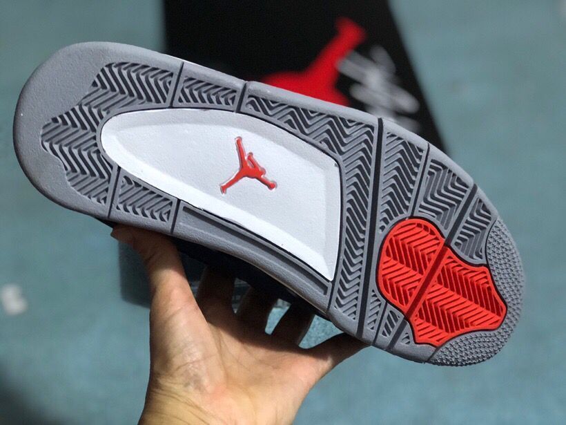 Underside of a sneaker showing a gray and white tread with red sections