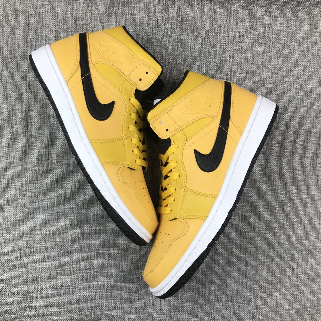 Top-down view of the pair showing yellow uppers, black Swooshes, and white midsoles.