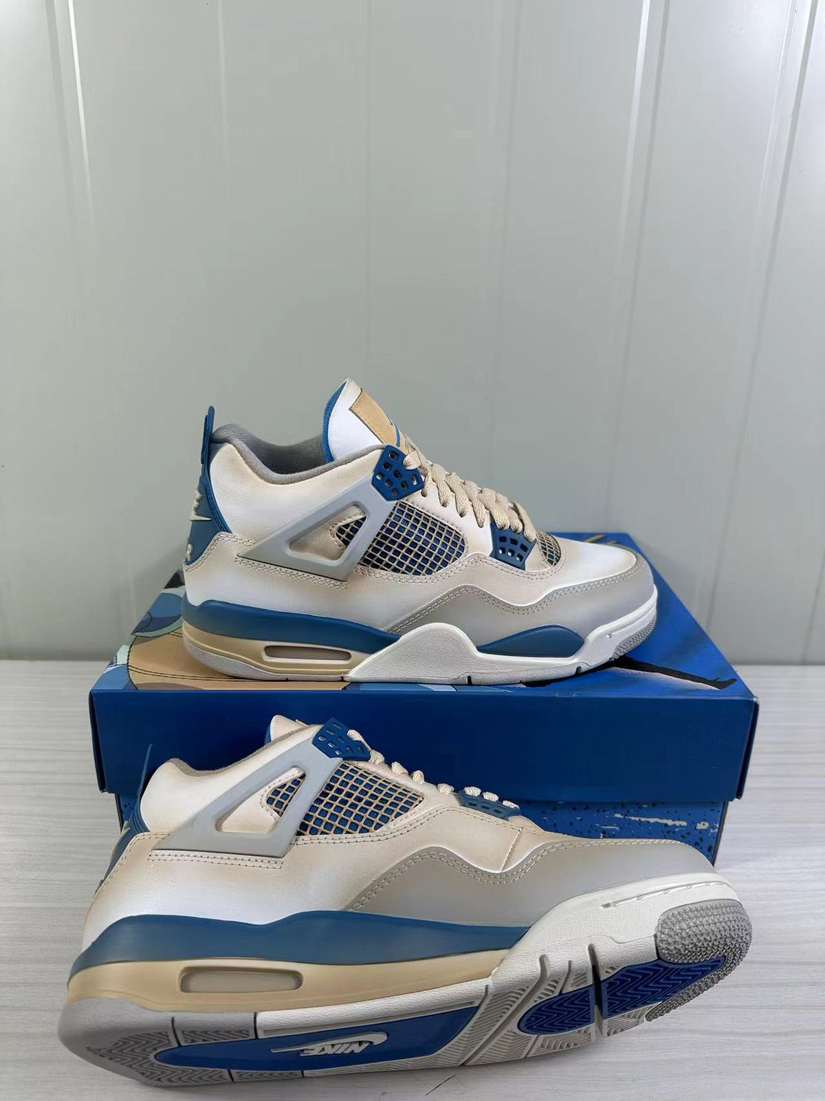 White and blue sneaker shown from the side with the outsole partially visible.