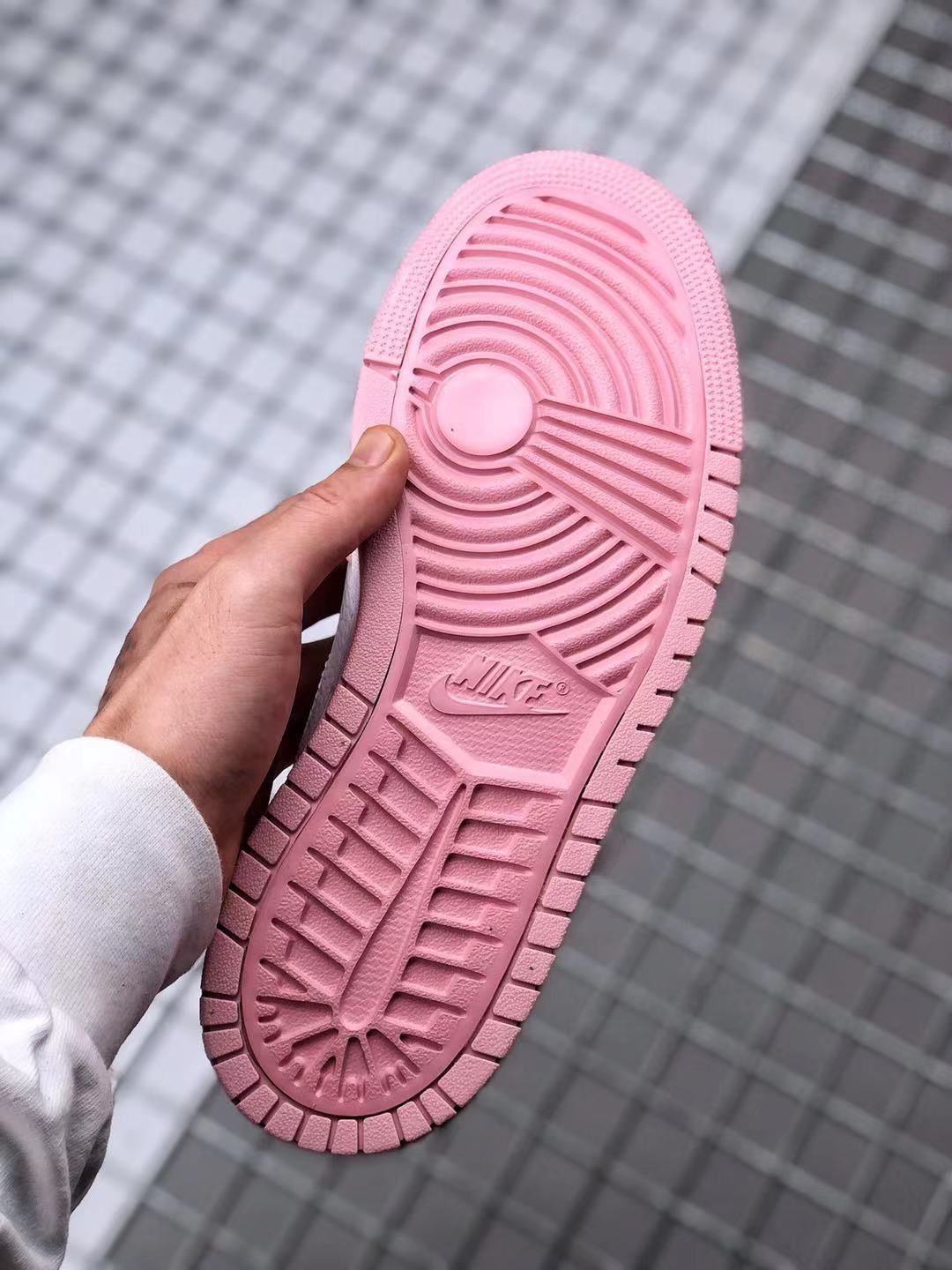 Underside view showing the pink outsole with circular and linear traction grooves.