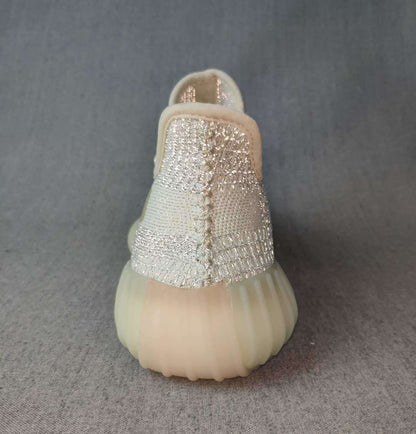 Rear view showing the padded heel collars, woven upper, and translucent cream outsole.