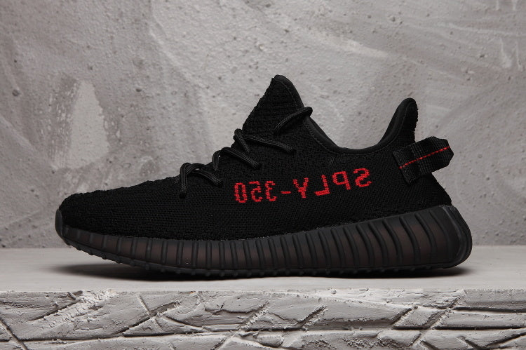 Side profile of a black sneaker with red side lettering and a ribbed sole.