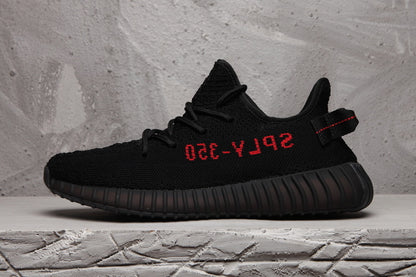 Side profile of a black sneaker with red side lettering and a ribbed sole.