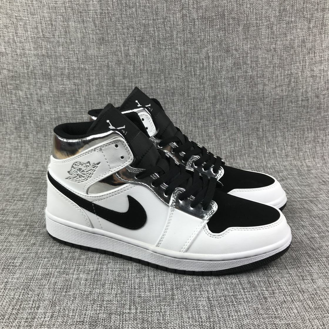 Three-quarter front view of the pair with black toe boxes, white overlays, and metallic silver eyelet panels.