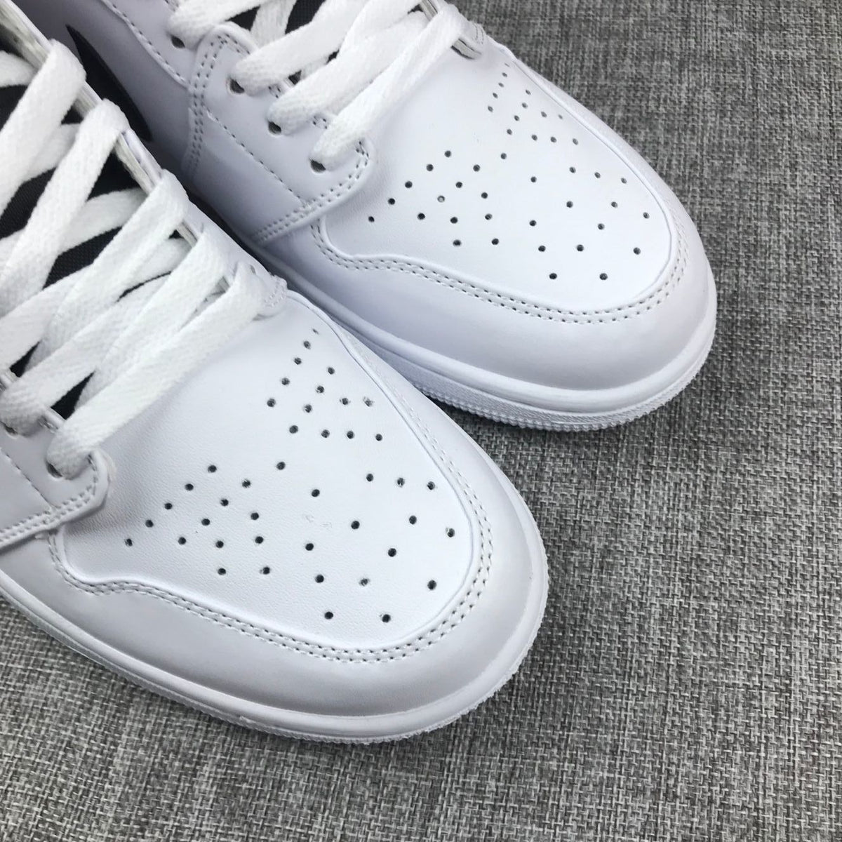 Close-up of the perforated white toe boxes and white flat laces.