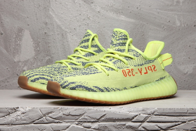 Pair of lime green 350 V2 sneakers displayed in a side-front view.