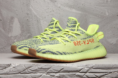 Pair of lime green 350 V2 sneakers displayed in a side-front view.